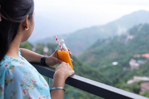 a young woman holding a drink in a glass jar at The Oasis Mussoorie - A Member of Radisson Individuals in Mussoorie