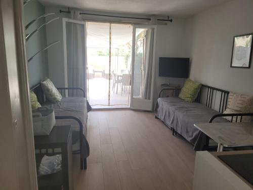 un salon avec un canapé et une table dans l'établissement Petit coin de paradis au soleil près de la mer, à Saint-Cyr-sur-Mer