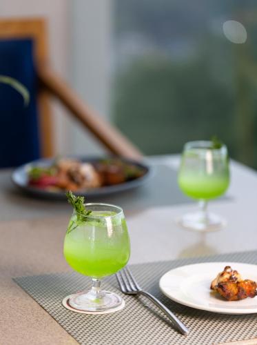 a table with two glasses of juice and a plate of food at The Oasis Mussoorie - A Member of Radisson Individuals in Mussoorie