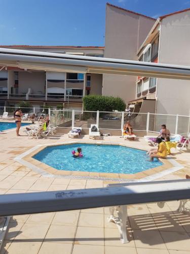 un groupe de personnes dans une piscine dans l'établissement Appartement T2 pour 4 personnes, à Plage dʼArgelès
