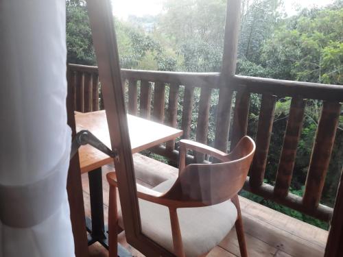 a wooden balcony with a table and a chair at The Boat Homestay and Spa in Balige