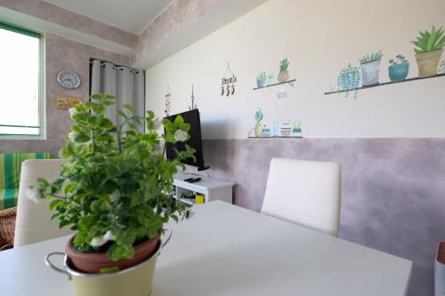 une table blanche avec une plante en pot sur elle dans l'établissement VILLETTA A SCHIERA DUE vicino MALDIVE DEL SALENTO, à Torre Pali