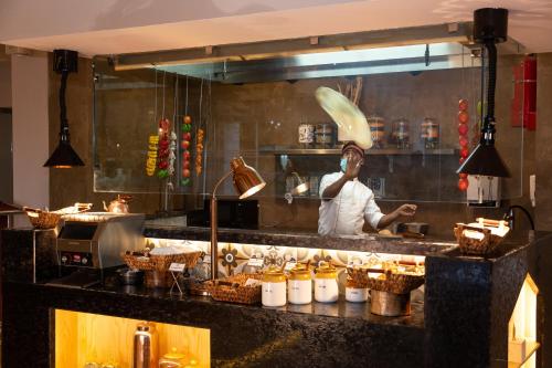 a chef preparing food in a restaurant kitchen at The Oasis Mussoorie - A Member of Radisson Individuals in Mussoorie