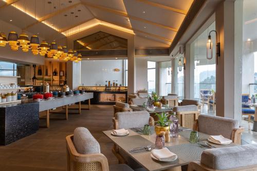 a restaurant with tables and chairs and a kitchen at The Oasis Mussoorie - A Member of Radisson Individuals in Mussoorie