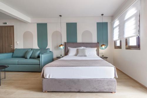 a bedroom with a bed and a blue couch at 9 Luxury Rooms in Sarti