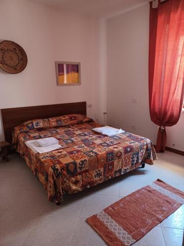 Un dormitorio con una cama y una cortina roja. en Appartamento per vacanza, en Castelsardo