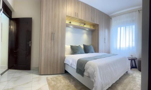 una camera con un grande letto e una parete in legno di The Nicoletta Apartment 104 a Kampala
