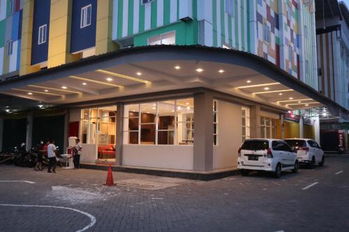 D'Carol Hotel في سورابايا: واجهة محل فيه سيارات تقف امامه