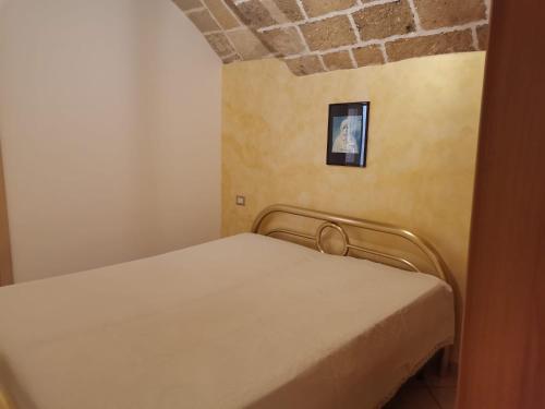 un piccolo letto in una camera con muro di mattoni di Casetta della Purità a Gallipoli