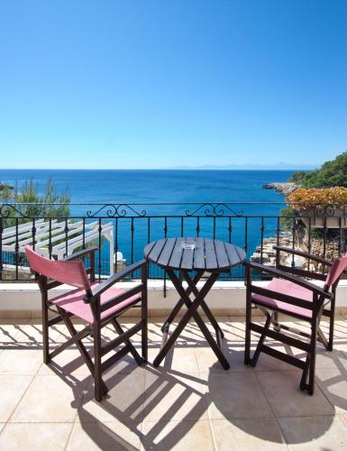 a table and chairs on a balcony with the ocean at Yalis Hotel in Votsi