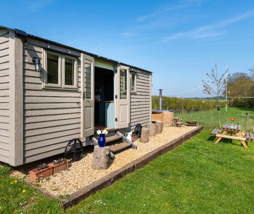 a tiny house in a yard with a picnic table at Old King William Shepherd Huts and Private Hot Tubs in North Norfolk in Hunworth