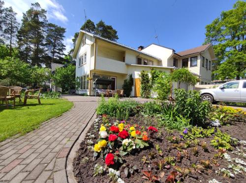 a garden in front of a house with flowers at Apartments Elina Viktorijas Street in Jūrmala