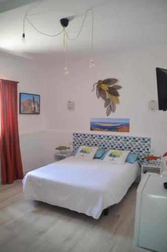 a bedroom with a large white bed in a room at HOTELITO RURAL GA7COLORES only adult in Montaña Blanca