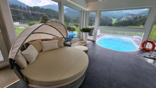 a room with a bed and a swimming pool at Hotel Vienna in San Martino di Castrozza