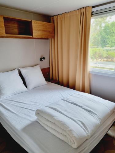 Ce lit se trouve dans un dortoir doté d'une fenêtre. dans l'établissement Mobil home camping Les ViVIERS Cap Ferret, à Claouey