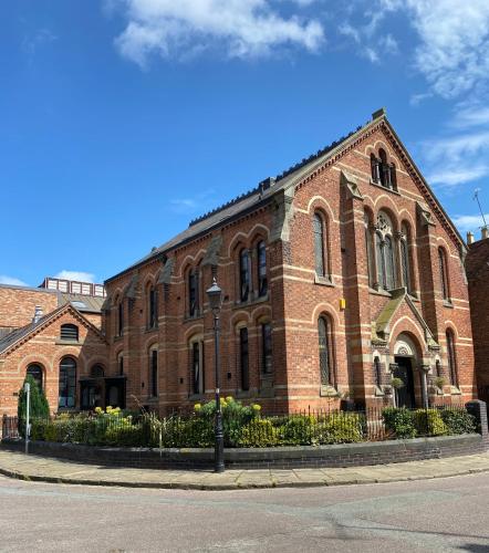 a large brick building on the corner of a street at Boutique Chapel Apartment within City Walls in Chester
