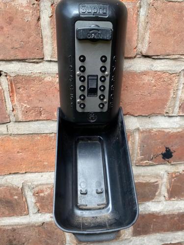a black soap dispenser attached to a brick wall at Boutique Chapel Apartment within City Walls in Chester