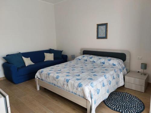 a bedroom with a bed and a blue couch at Case Pagano Mare in Taormina