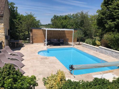einen Pool mit einem Pavillon und einer Terrasse in der Unterkunft Le Rouge & Blanc in Mormont