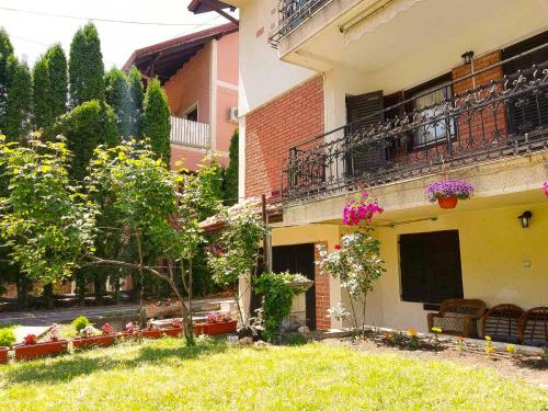 a building with a yard with chairs and flowers at Vila Nikola in Soko Banja