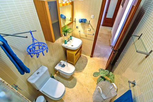a bathroom with a white toilet and a sink at Ribera De Luxe Central Apartment with Ascensor in El Puerto de Santa María