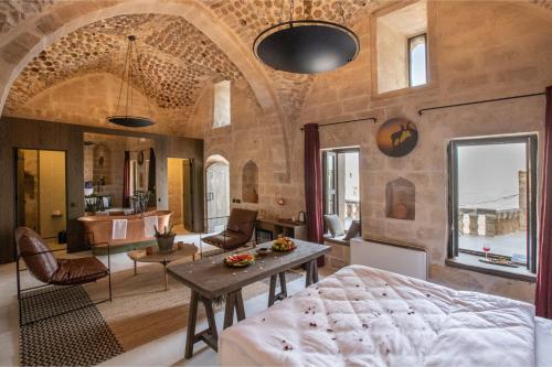 ein Schlafzimmer mit einem Bett und ein Wohnzimmer in der Unterkunft Mirsoum Hotels in Mardin