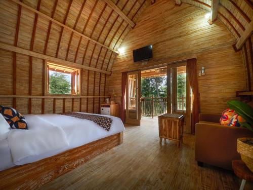 - une chambre avec un lit dans une pièce dotée de murs en bois dans l'établissement Wisnu Lumbung Uluwatu, à Uluwatu