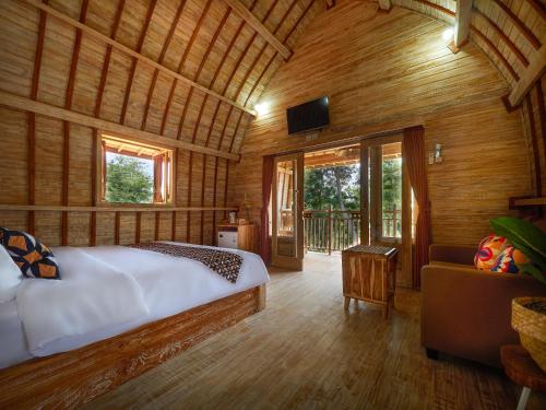 a bedroom with a bed in a room with wooden walls at Wisnu Lumbung Uluwatu in Uluwatu