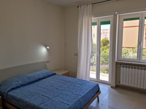 a bedroom with a bed and a large window at Casa Sofia in Gaeta