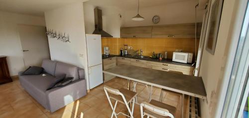 a kitchen with a couch and a table and a refrigerator at Résidence les Arts 2 in Arles