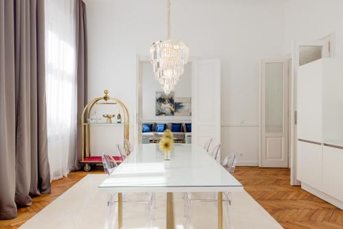 a dining room with a white table and a chandelier at RAFAEL KAISER - Premium Apartments City Centre - Contactless Check-In in Vienna