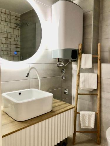 a bathroom with a white sink and a mirror at Apartmani CUBE A in Medulin
