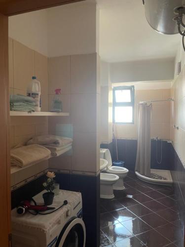 łazienka z toaletą i pralką w obiekcie Vlore apartament 1 we Wlorze