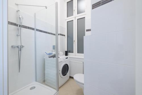 a bathroom with a shower toilet and a washing machine at RAFAEL KAISER - Premium Apartments City Centre - Contactless Check-In in Vienna