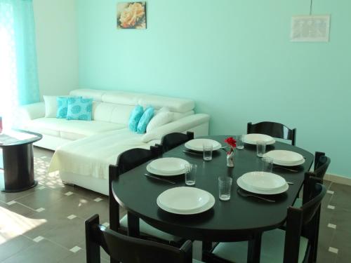 uma sala de estar com uma mesa preta com cadeiras e um sofá em Apartman Crikvenica 30103 - Zdravko em Crikvenica