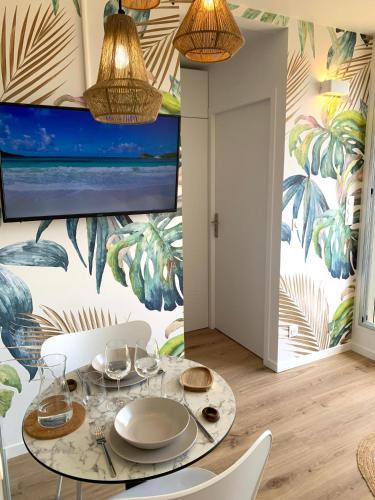 une salle à manger avec une table et des chaises ainsi qu'une fresque murale. dans l'établissement Élégant appartement T2 en 1ère ligne de l'Étang de Thau avec terrasse - Cures et vacances, à Balaruc-les-Bains