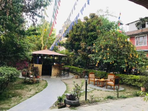 a garden with a table and chairs and a tree at Cloud 9 Garden in Kathmandu