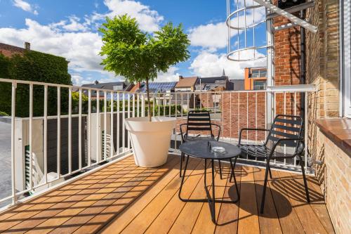 a balcony with chairs and a table on a building at Guesthouse de la Paix in Poperinge