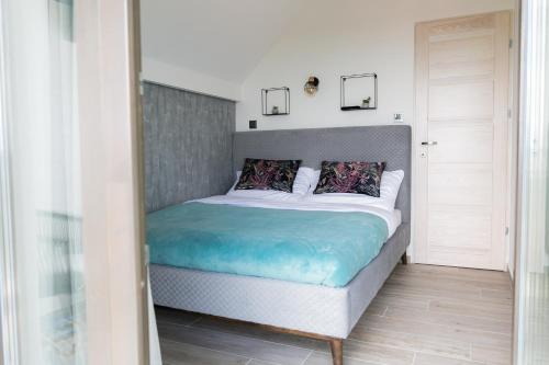 a bedroom with a large bed with a blue blanket at Flow House&Garden in Badacsonytomaj