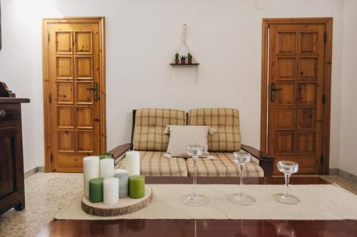 sala de estar con sofá, velas y copas de vino en Trulli Pinnacoli, en Locorotondo