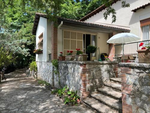 a house with a stone retaining wall and a stone staircase at Casetta Lake and Sun in Labro