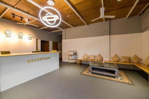 a large room with a reception desk and clocks on the wall at Shine Residency in Mysore