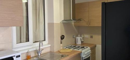 a small kitchen with a stove and a sink at Grace's Home in Rotherham