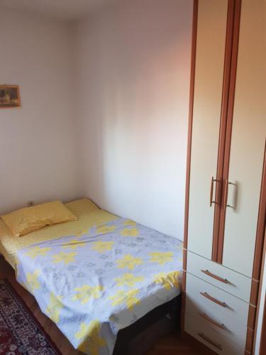 a small bedroom with a bed and a cabinet at Apartman Petar in Trebinje