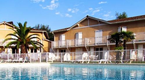 un resort con piscina di fronte a un edificio di Petit oasis avec piscine ad Anglet