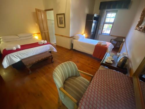 ein Hotelzimmer mit 2 Betten und einem Stuhl in der Unterkunft Schulteheim Hotel in Uniondale