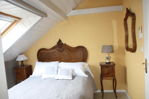 a bedroom with a bed with white sheets and pillows at GITE DU CLOS PAISIBLE in Jebsheim