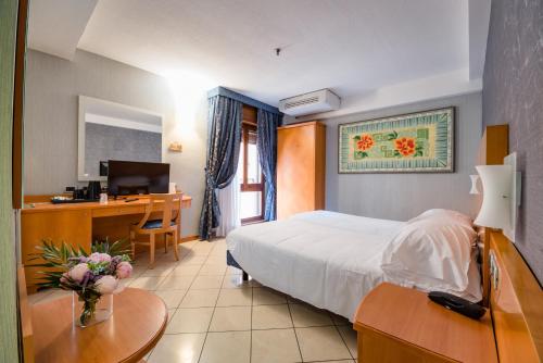 1 dormitorio con 1 cama y escritorio con ordenador en Hotel Centrale, en Bolonia