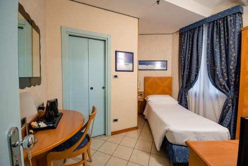 a small hotel room with a bed and a desk at Hotel Centrale in Bologna