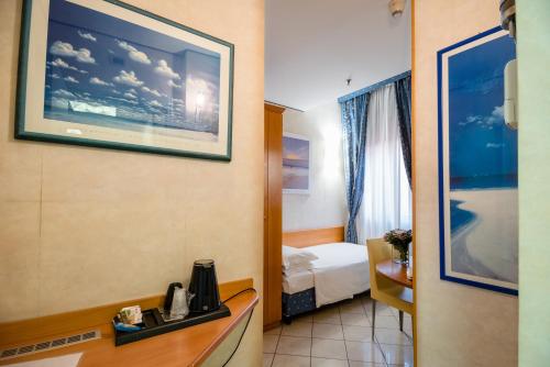a hotel room with a bed and a tv on the wall at Hotel Centrale in Bologna